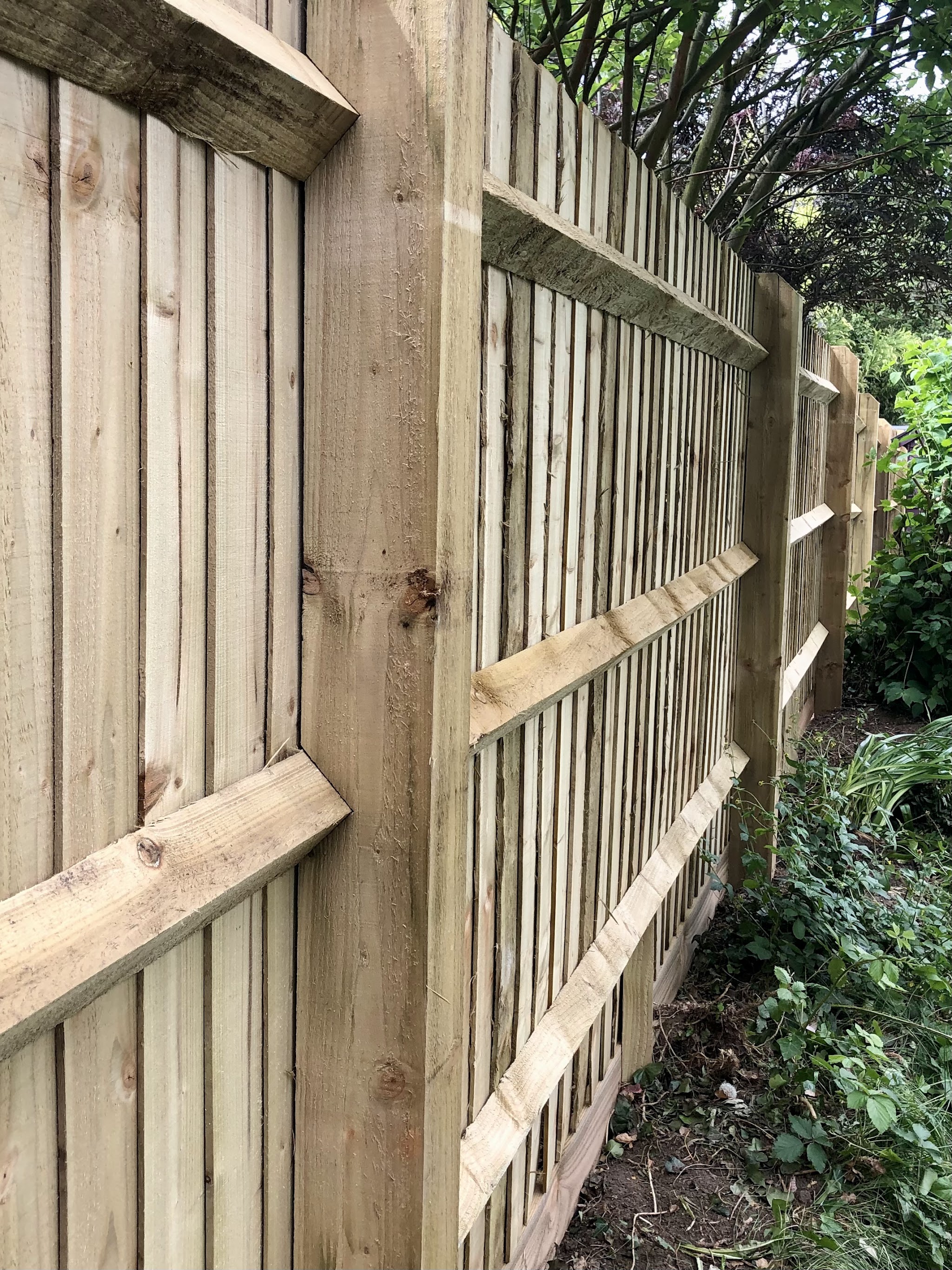 Close-up of a new close-board fence with arris rails